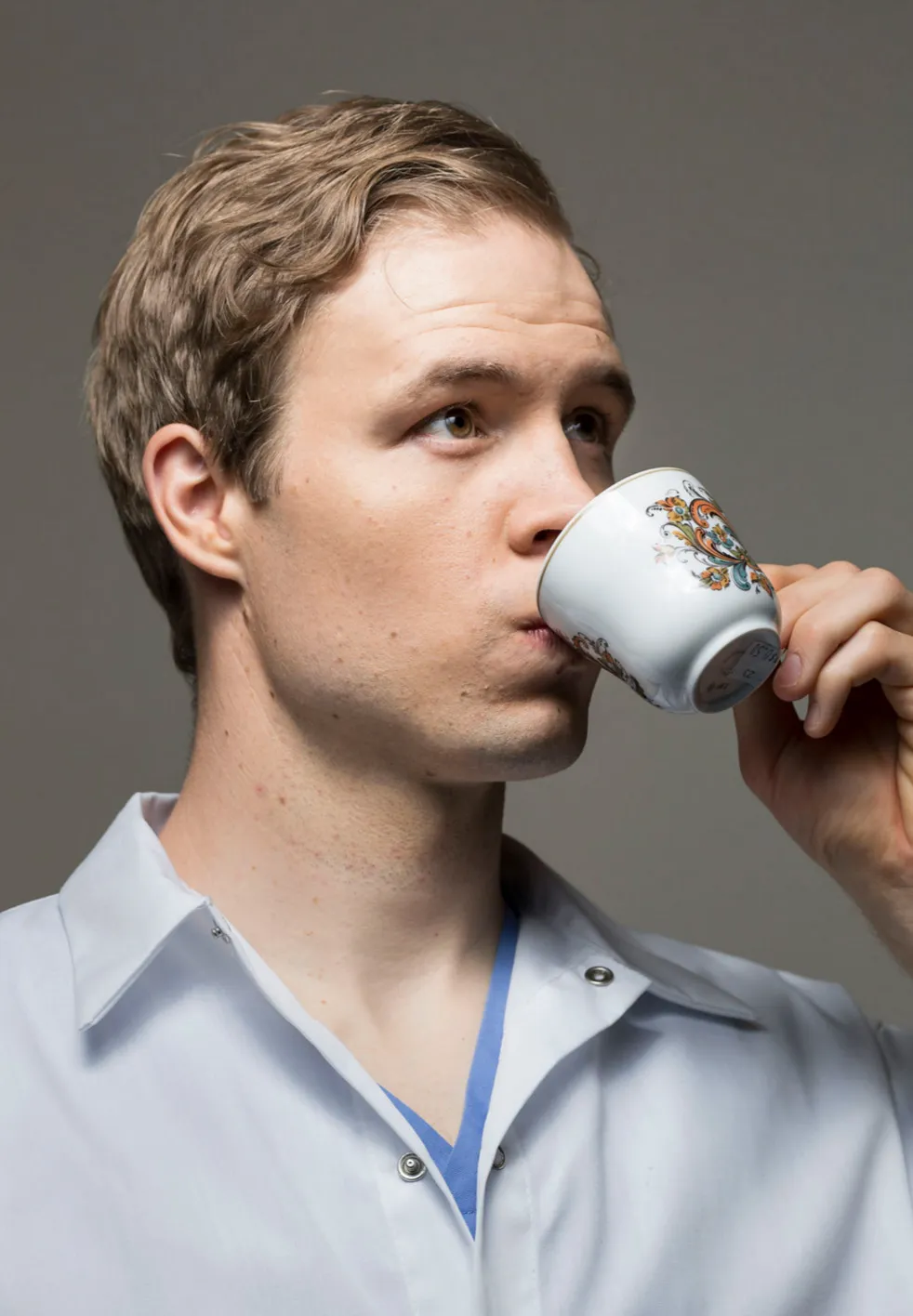 James Perry sipping from a fancy teacup